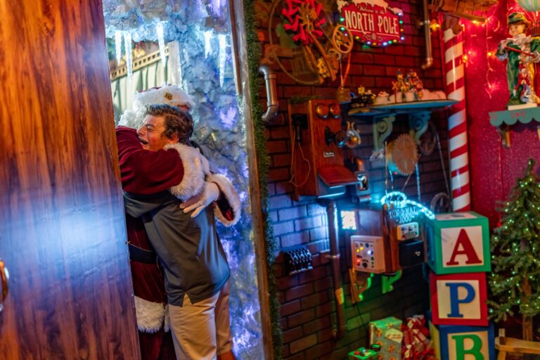 Onceuponanisland Christmas Tour Santa Hugging Child North Pole Decor